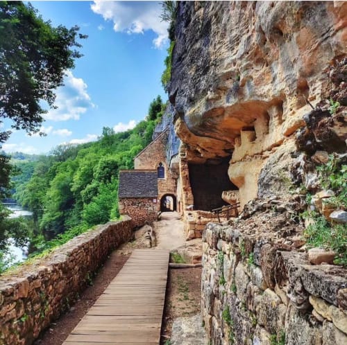 Sentier de pierre menant à la Maisonaurinko B&B taillé dans la falaise surplombant la rivière à Thenon, France