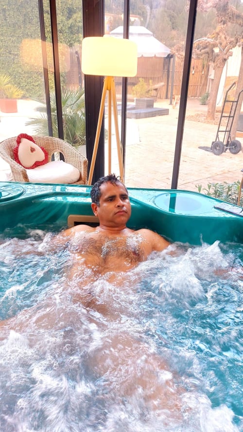 Man relaxing in hot tub at La Bergerie Du Moulin B&B in Taradeau, France