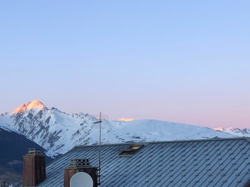 Pics alpins enneigés au lever du soleil au-dessus du toit de l'hôtel L'écrin des sapins, Aime-la-Plagne