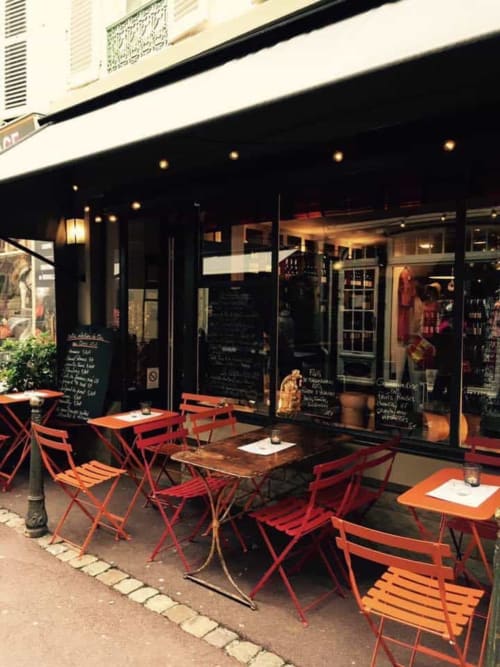 Outdoor terrace seating at Hotel Le Trouville in Trouville-sur-Mer with red chairs and tables