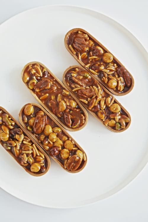 Éclairs au chocolat et fruits secs sur assiette blanche à l'Hôtel Le Trouville, Trouville-sur-Mer