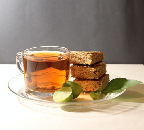 Tasse de thé avec gâteau d'épices et tranches de citron vert, ambiance hospitalière de l'Hôtel Le Trouville