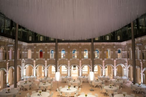 Élégante salle de banquet de l'Hôtel Le Trouville avec tables rondes et colonnade en arc donnant sur la cour