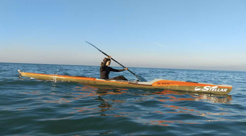 Kayakiste pagayant dans les eaux calmes près de Trouville-sur-Mer, France, face à l'Hôtel Le Trouville