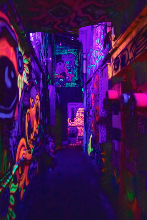 Couloir néon avec graffitis vibrants en violet, rose et vert à l'Hôtel Le Trouville, Trouville-sur-Mer