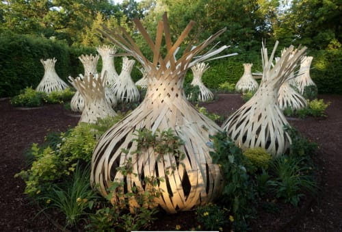 Sculptural metal onions at Locacharme garden in Blois, France, with lush greenery and hedges