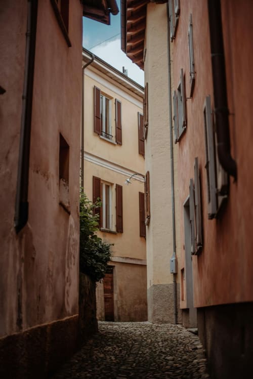 Estrecho callejón empedrado entre edificios de terracota en la casa rural Casale 905 B&B de Crecchio, Italia, bajo un cielo azul