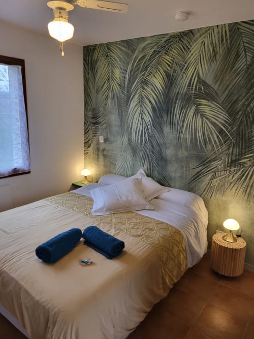 Modern hotel bedroom at Cheverny La Vie Est Belle with tropical palm wallpaper, white bedding, and warm brass lighting