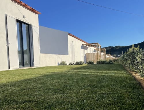 Star Host property in Bordeira with modern white building, manicured lawn, and hillside views under clear blue sky