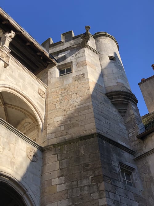 Tour en pierre historique avec tourelle cylindrique à la Conciergerie Des Climats à Beaune, France, présentant une architecture médiévale