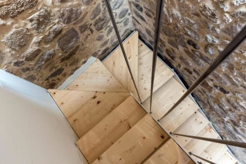 Wooden staircase with stone walls in Centro Da Viola eco-design room, Olbia