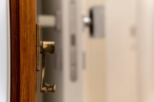 Antique brass door handle on wooden door at In Centro Da Viola eco hotel in Olbia