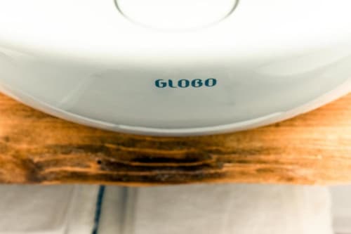 Globo ceiling lamp with wooden arm detail in eco-friendly hotel room at In Centro Da Viola, Olbia