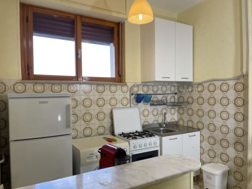 Cucina moderna negli Appartamenti Rigiariloo di San Giacomo degli Schiavoni, con elettrodomestici bianchi e piastrelle decorate