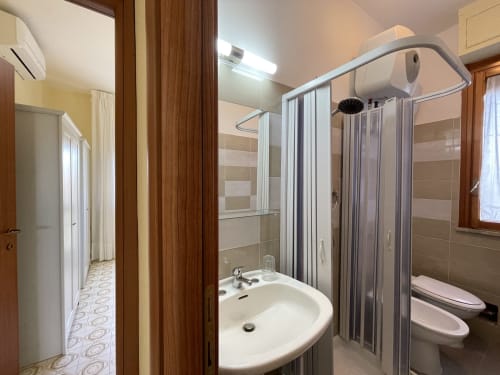 Bagno moderno degli Apartments Rigiariloo con doccia, lavabo e toilette a San Giacomo degli Schiavoni