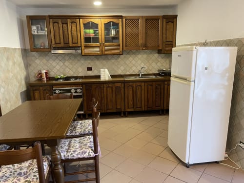 Cucina e zona pranzo negli Appartamenti Rigiariloo, San Giacomo degli Schiavoni, Italia con mobili in legno e bianco