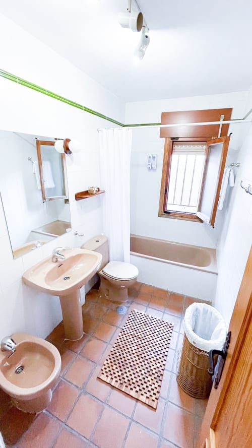 Amplio baño de villa con doble lavamanos, bañera y azulejos de terracota en Casa Rural Villa del Jerte