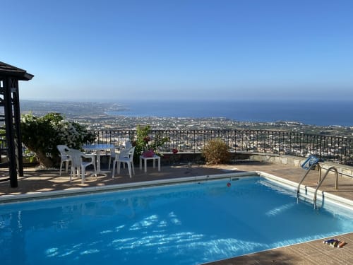 Piscine privée chauffée et vue panoramique exceptionnelle sur 25 km de littoral vers Paphos, Peyia, Coral Bay et Agios Georgios. Pergola ombragée sur la plage de la piscine