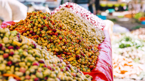 Colorful spiced snacks and preserved foods at a Marrakesh market stall near Riad Palau