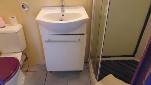 Meuble vasque blanc moderne avec lavabo arrondi et rangements au gîte Caribgites à Sainte-Anne, Guadeloupe