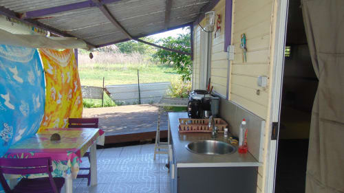 Cuisine cottage Caribgites à Sainte-Anne avec terrasse extérieure, évier, cuisinière et vue sur le jardin