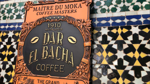 Dar el Bacha coffee sign, featuring ornate Moroccan zellige tile backdrop in geometric patterns