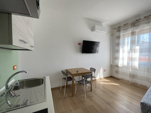 Moderno appartamento Rigiariloo Home con tavolo da pranzo, cucina, TV e vista sulla città a San Giacomo degli Schiavoni