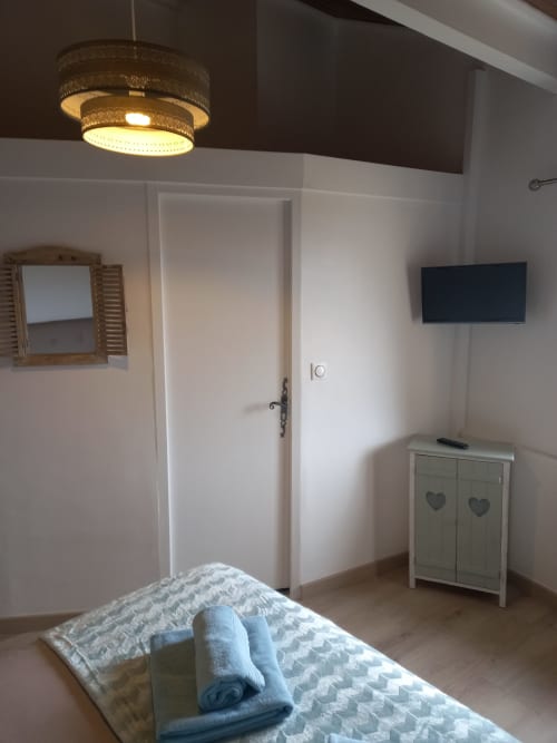 Chambre toute équipée avec télévision, salle de bain privative et un décors chaleureux.