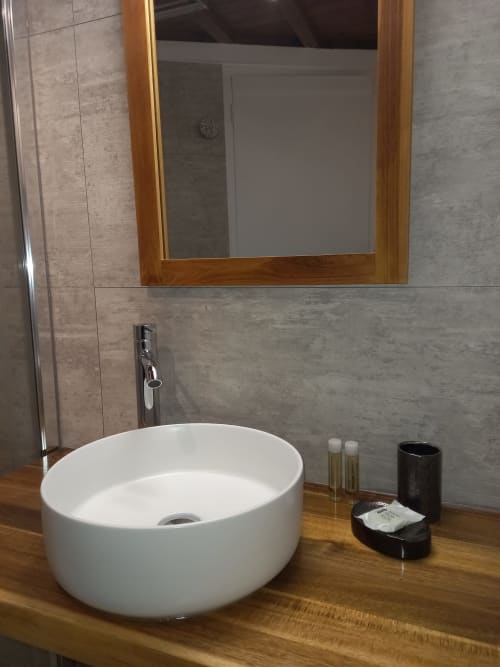 Salle de bain avec douche et produits d'accueil : gel douche, champoing et savon.