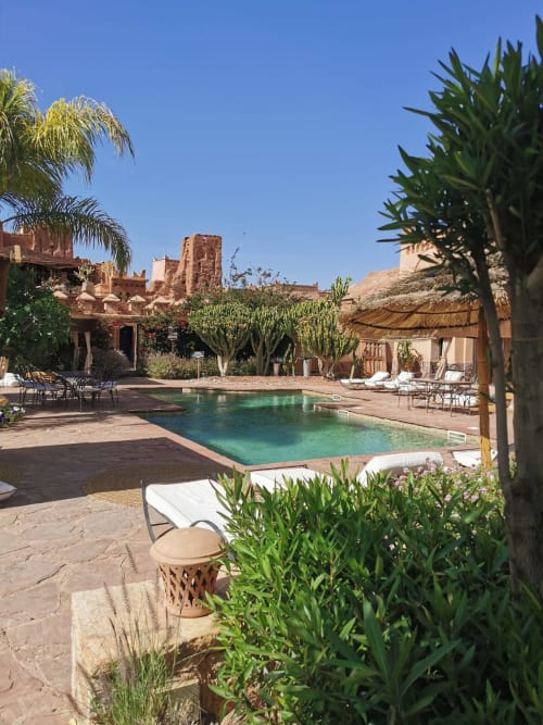 piscine aux eaux turquoise, architecture marocaine traditionnelle, palmiers et zones de détente