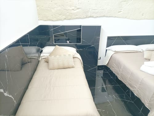 Due letti gemelli con biancheria bianca in una moderna camera dell'hotel Newhouse a Bari, Italia, con pavimento in marmo scuro e vista sulla città.