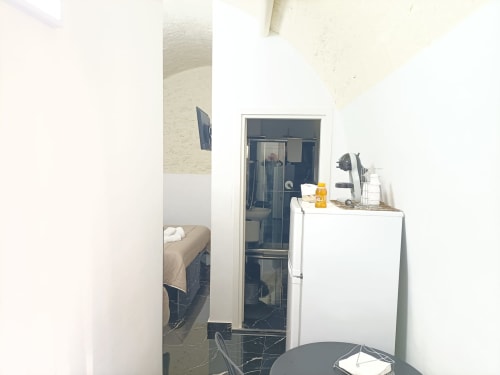 Camera compatta dell'hotel Newhouse Bari con frigorifero bianco, bagno e letto visibili dall'ingresso