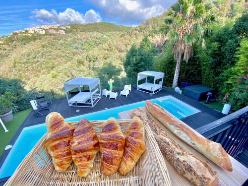 Fresh croissants and baguettes on Villa Colina's poolside deck with mountain views in Mandelieu la Napoule