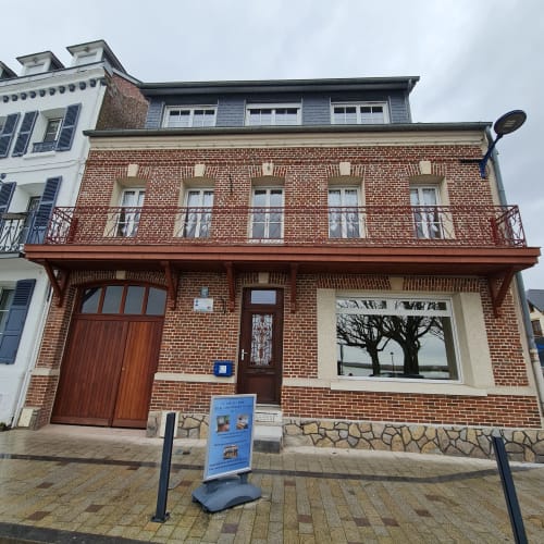 Gîte Les Mouettes Blessées, bâtiment en brique avec porte rouge et grande fenêtre au Crotoy, France