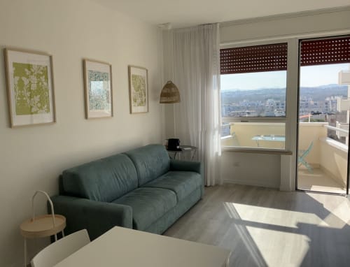 Modern Harbour View Suite at Lamar Suites Seafront Apartments in Misano Adriatico with green sofa, dining table, and coastal