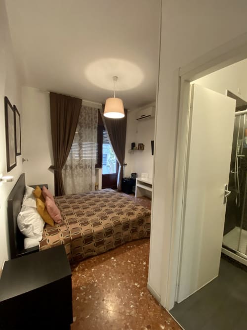 Standard double room at Casa Castagna B&B in Salerno with bed, pendant light, curtained window, and ensuite bathroom