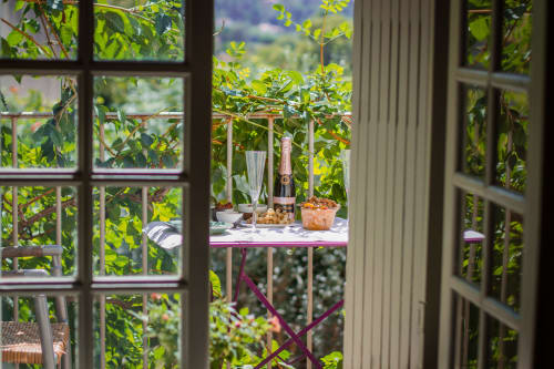 Garden view from Ancienne Maison des Gardes balcony with champagne and appetizers in Lourmarin village