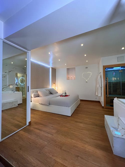 Vue sur la chambre de la love room bulle évasion. Un miroir à gauche et un sauna à droite.
