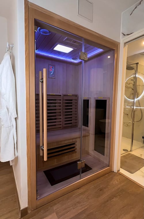 Le Sauna infrarouge de la Bulle évasion, et son éclairage led. On voit un peignoir à gauche et le reflet d'un miroir à droite.