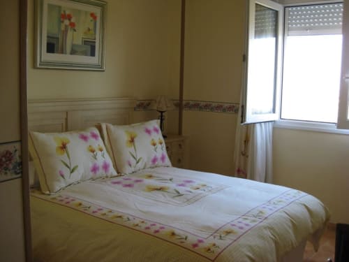 Bedroom with floral bedding and pillows at Complejo Turístico Retiro del Teatro, Almagro