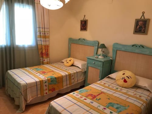 Cozy twin bedroom at Complejo Turístico Retiro del Teatro in Almagro with turquoise headboards, colorful bedding, and
