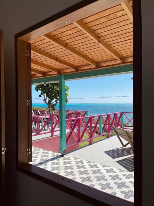 Vista al mar desde habitación del boutique lodge Seaflower con vigas de madera, barandal rosa y vistas al océano turquesa en San Andrés.