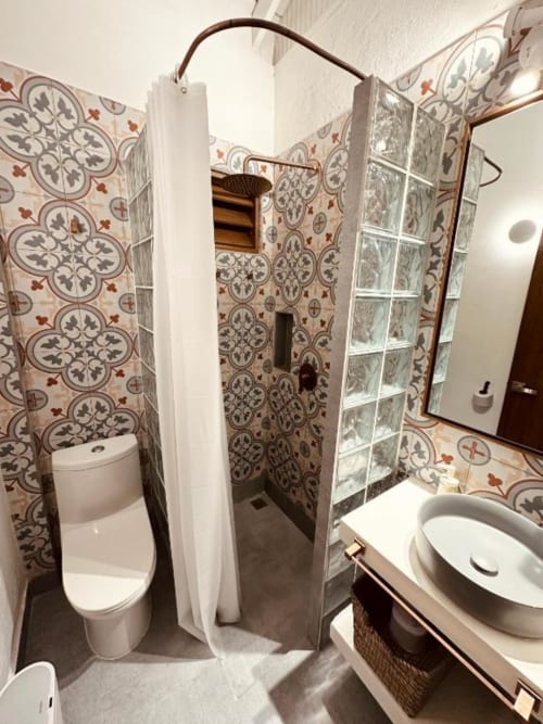 Baño de la boutique hotel Seaflower con azulejos decorativos ornamentales, ducha, inodoro y lavamanos en San Andrés