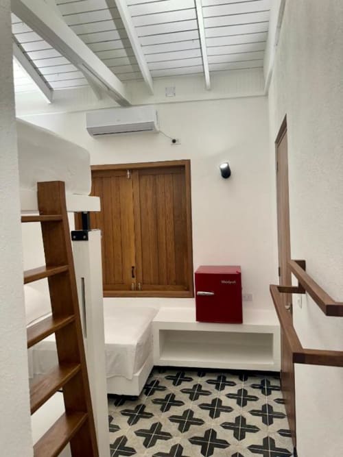 Habitación moderna en el boutique lodge Seaflower de San Andrés con puertas de madera, refrigerador rojo y piso con patrón geométrico