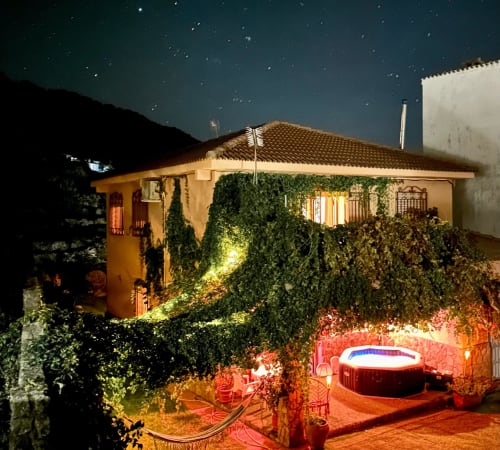 Casa Rural Villa del Jerte night view with terrace, hot tub, ivy-covered walls and starry sky in El Torno, Cáceres