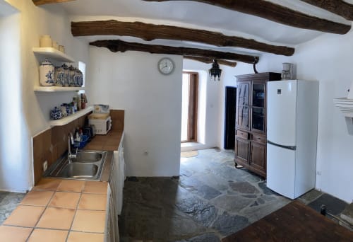 Amplia y cómoda cocina tradicional Alpujarreña con vigas de castaño, mesa comedor y detalles de decoración de Casa Josefa Capileira