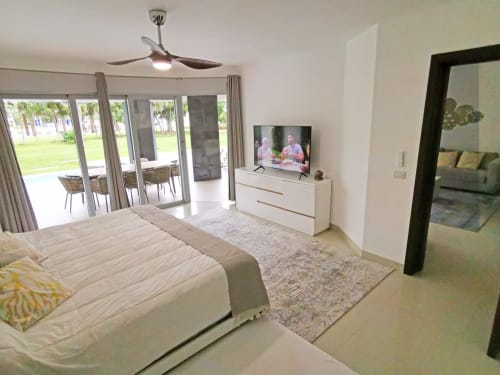 Amplia recámara principal en Condo Paraiso del Resort Beachfront Mareazul con cama queen, TV de pantalla plana y balcón con vista al océano