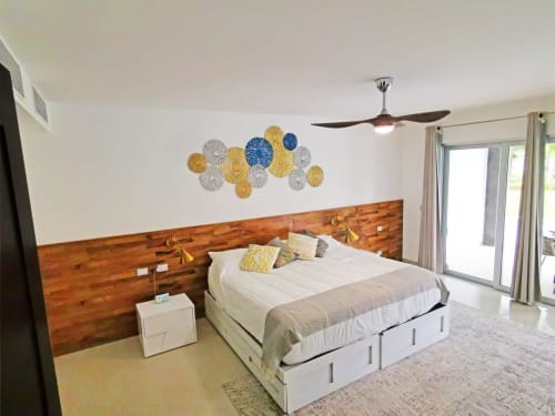 Dormitorio moderno de condominio frente al mar en Mareazul Resort con cabecero de madera, cama blanca, arte decorativo en pared y ventilador de techo