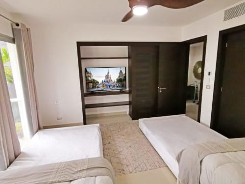 Habitación moderna en el Mareazul Beachfront Resort en Playa del Carmen con camas gemelas, TV de pantalla plana, acentos de madera oscura y