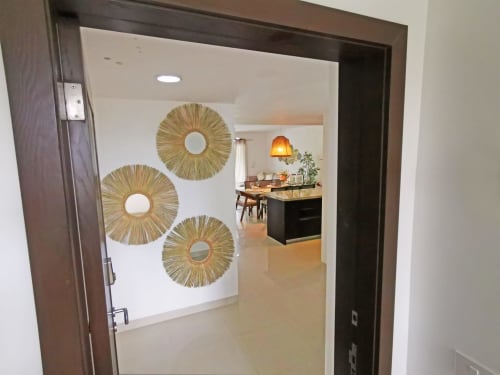 Entrada luminosa a condominio Mareazul con espejos decorativos de paja y moderna área de comedor en Playa del Carmen